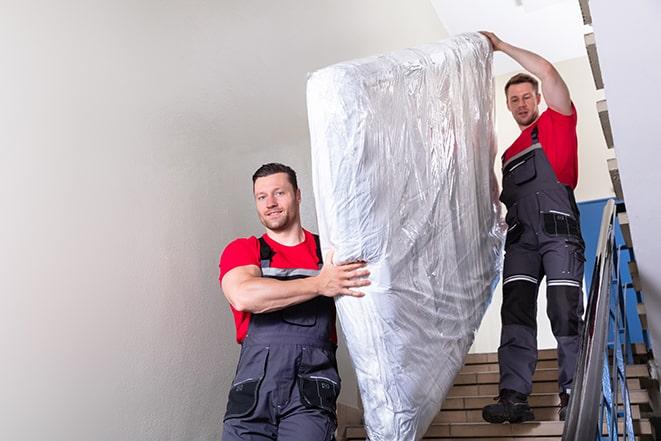 tackling the task of transporting a box spring out of a building in Brush Creek TN